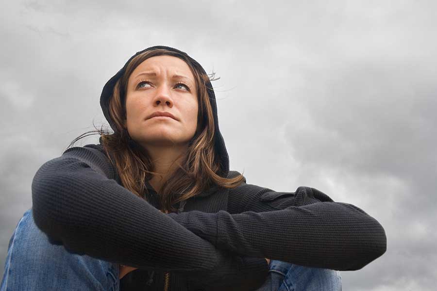 Young woman in hoodie worried about molly drug use.