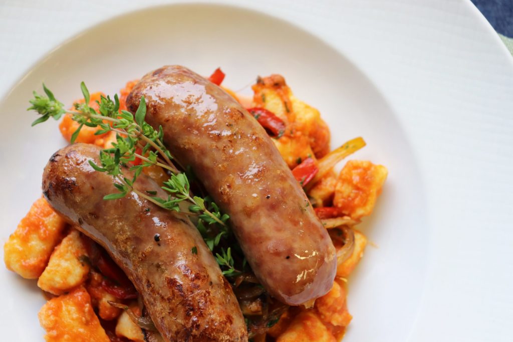 Grilled Italian Sausage. With peppers and onions over potato gnocchi marinara